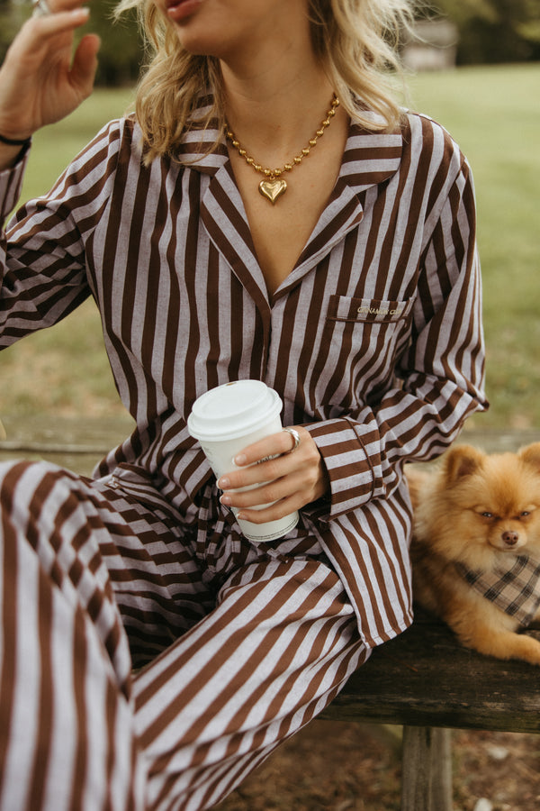 Model showcasing the Stormy Espresso Set, featuring a cozy brown top with an embroidered coffee cup and matching striped lounge pants.